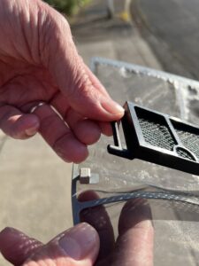 Close up showing hands unclipping an air purifying filter from a Daikin mini-split air filter